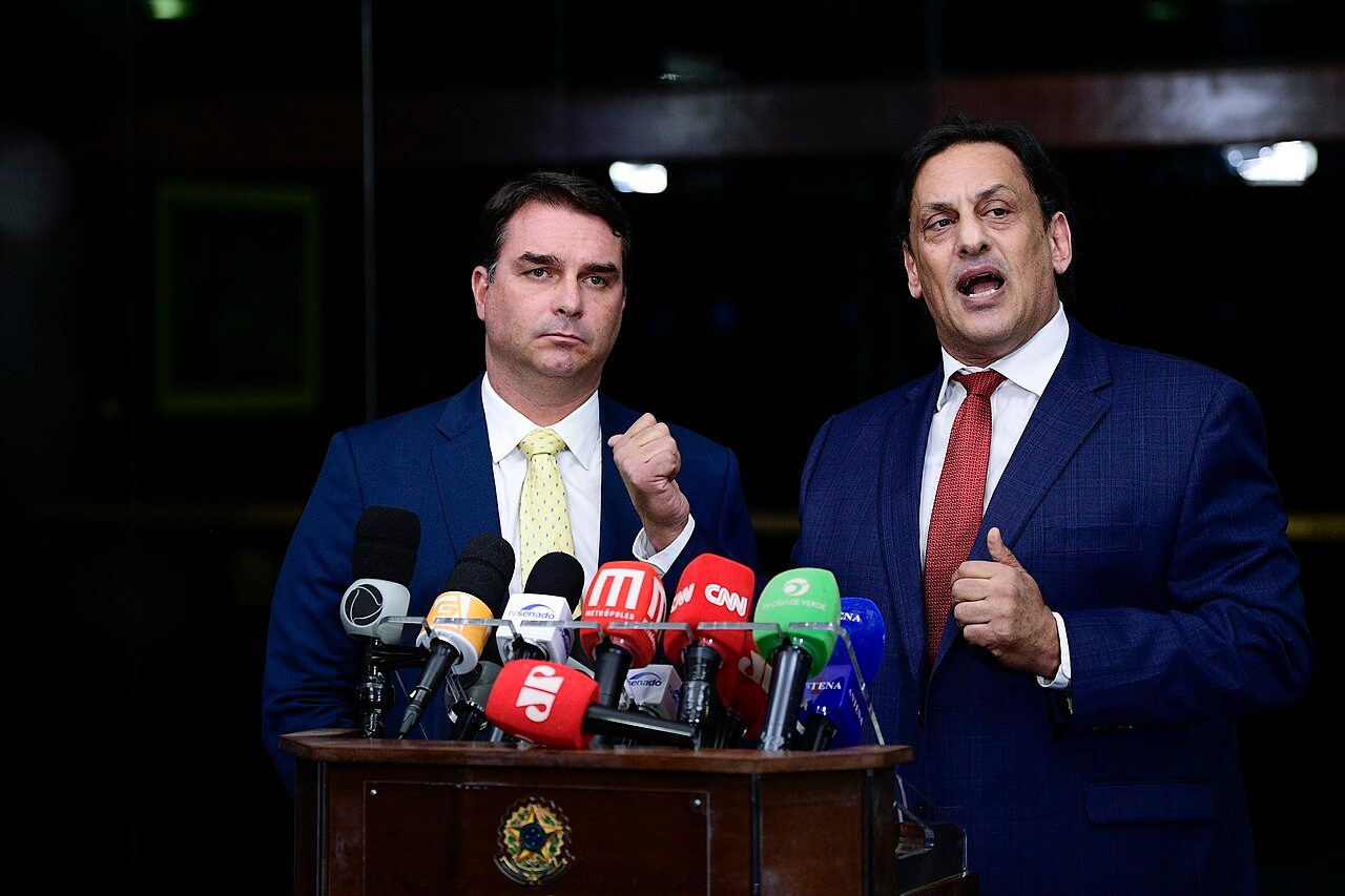 Brazilian Sen. Flávio Bolsonaro speaking to reporters with lawyer Frederick Wassef