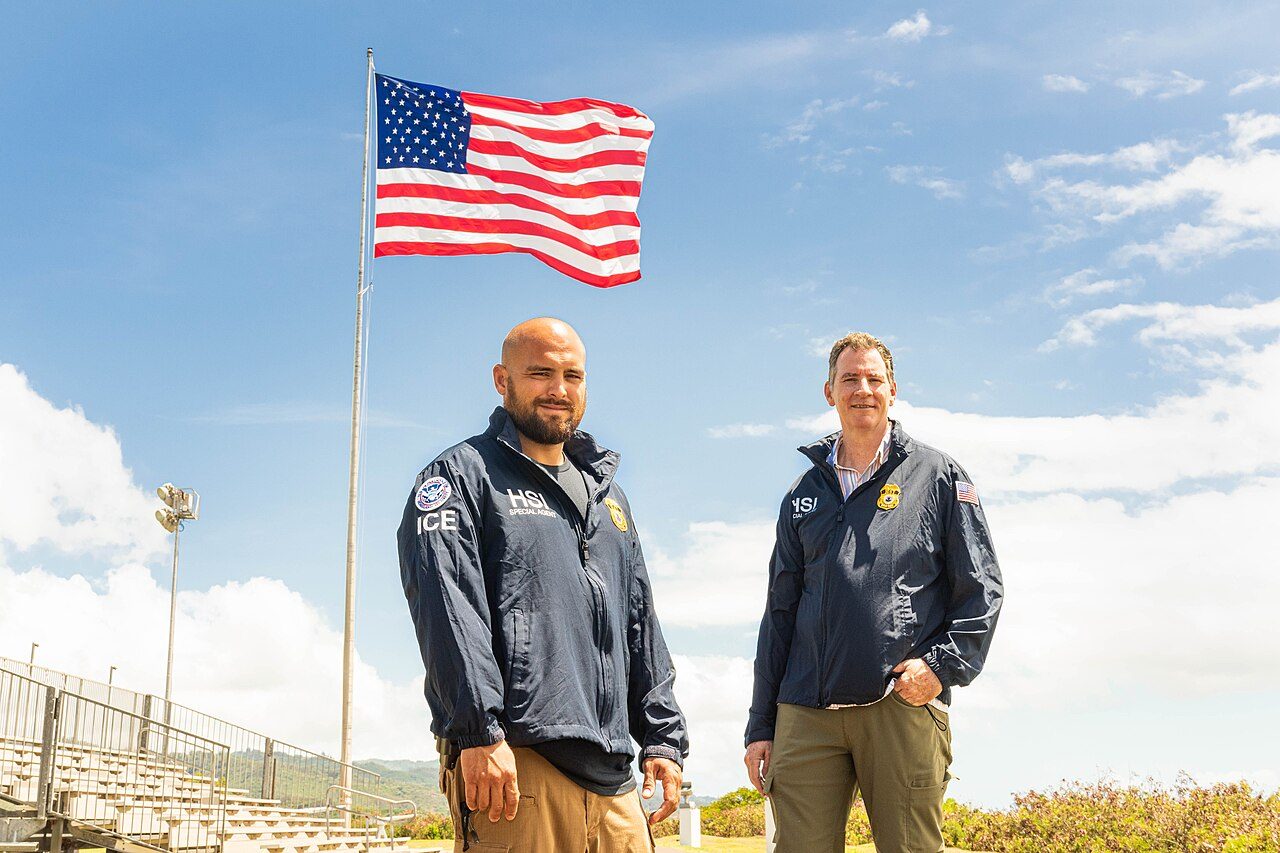 File photo of Homeland Security Investigations special agents in Honolulu standing beneath a U.S. flag